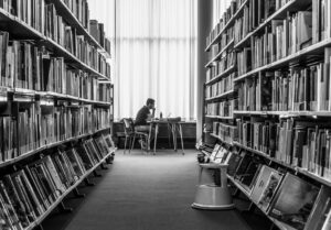 Pessoa estudando sozinha em uma biblioteca como símbolo de motivação e busca por conhecimento