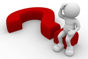 Um boneca sentado num ponto de interrogação. Representando: Como Superar o Vitimismo e Assumir o Controle