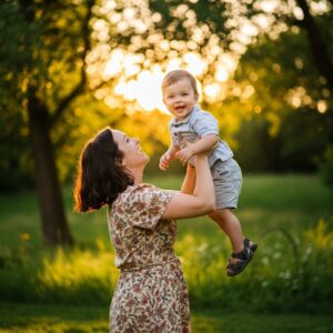 Mãe levantando seu filho nos braços, ambos sorrindo, simbolizando as vitórias e conquistas da maternidade com propósito.